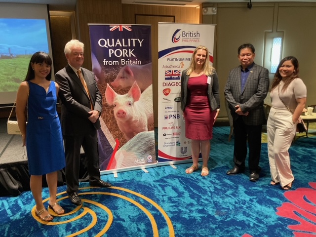 Group of five people next to Quality Pork from Britain banner